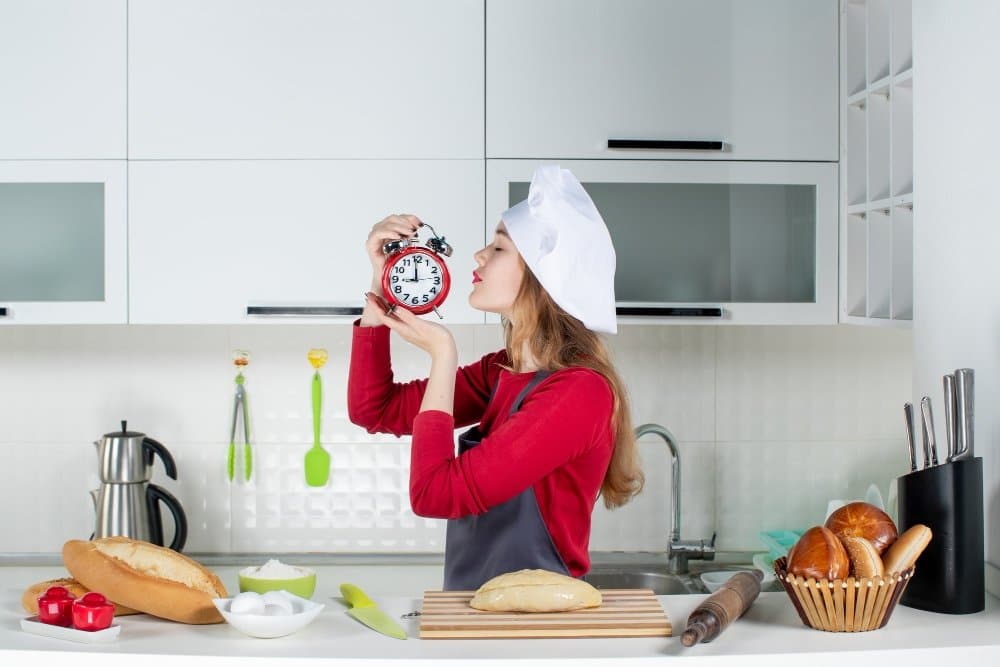 30-Minute Meals: Quick Dinner Ideas Your Family Will Love 4 A chef in a modern kitchen holding a clock, surrounded by bread and baking essentials, symbolizing the concept of time-efficient meal prep.