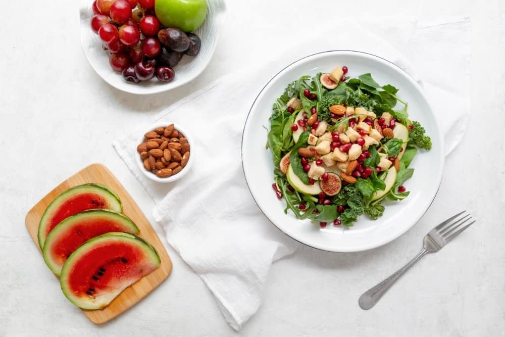 Quick Dinner Ideas for Family: Easy Meals in 30 min 2 Quick dinner ideas for family: Fresh green salad with apple slices, pomegranate seeds, figs, almonds, and a side of fruits and watermelon slices on a wooden board