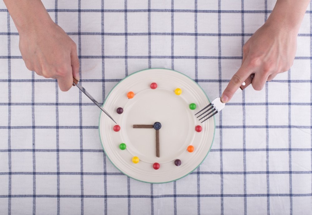 30-Minute Meals: Quick Dinner Ideas Your Family Will Love 3 A creative clock design made from colorful food items on a plate, with hands using a knife and fork, symbolizing quick meal preparation.