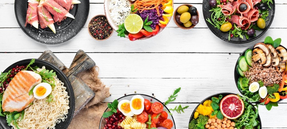30g Protein Lunch Ideas: Quick and Delicious Meals 2 30g Protein Lunch Ideas: A variety of 30g protein lunch bowls featuring grilled chicken, boiled eggs, fresh salads, chickpeas, vegetables, and healthy grains, arranged on a white wooden table.