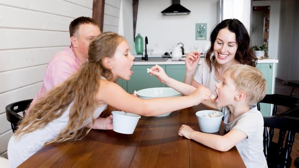 Easy Healthy Weeknight Dinners for Family 🍽️ 4 Easy Healthy Weeknight Dinners for Family" Family enjoying a healthy meal together at a dining table in a modern kitchen.