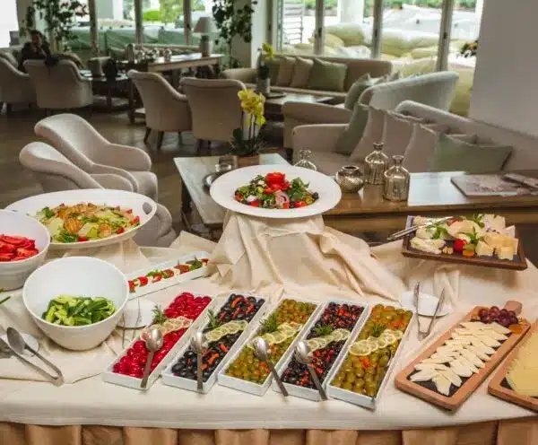 What to Feed 20 People for Lunch: Delicious & Easy Ideas 2 What to Feed 20 People for Lunch: "Buffet table with fresh salads, assorted olives, cheeses, and vegetables in a modern, cozy dining area."