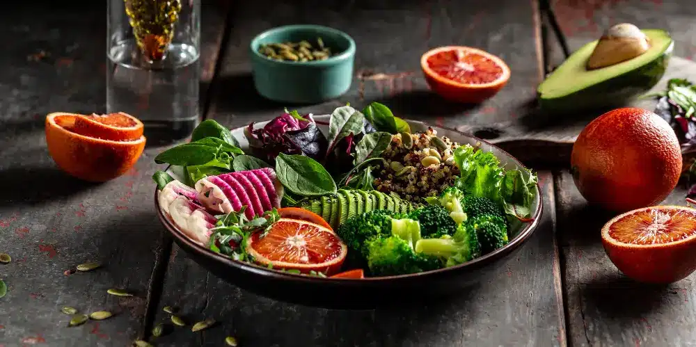 Vegan Food for Lunch: Delicious and Nutritious Choices 2 "Vibrant vegan lunch bowl with quinoa, broccoli, fresh greens, blood orange slices, and avocado"